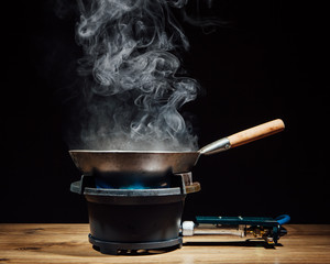 chinese wok pan on fire gas burner