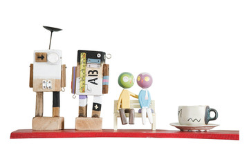 Fototapeta premium Colorful mini wooden robot models and coffee cup on red shelf is