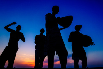 A group of africans sing national song and dance at the sunset