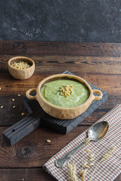 Broccoli cream soup with pine nuts, ears of corn, rustic