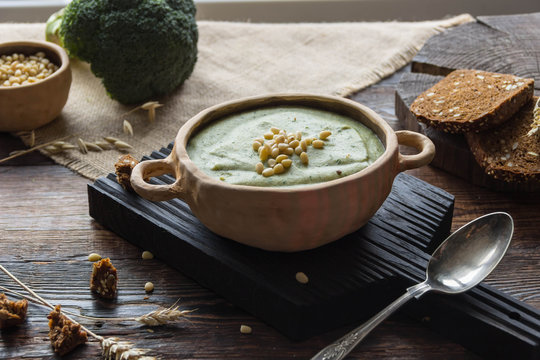 Broccoli cream soup with pine nuts and wholemeal bread, ears of corn, rustic
