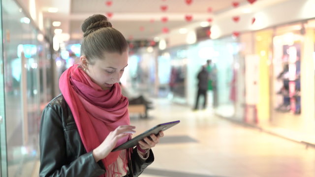Young girl using a tablet. smiling indoor in the shopping center. 4K