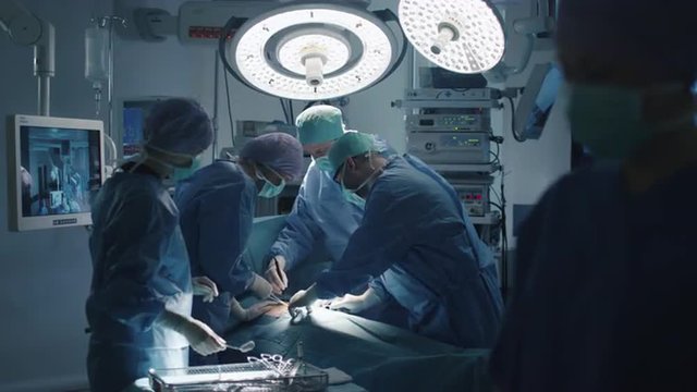 Medical Team Performing Surgical Operation in Modern Operating Room. Shot on RED Cinema Camera.