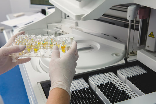 Lab Tech Loading Samples Into A Chemistry Analyzer