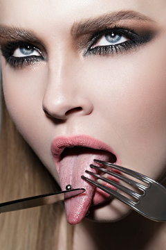 Girl eats her tongue by knife and fork
