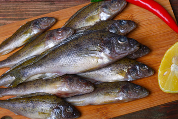 raw redfish ruff fish on the kitchen table with vegetables and lemon