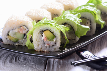 Sushi rolls on wooden background