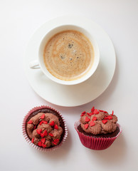 tazza di caffè, la parola amore da piccoli cuori decorativi e cupcakes cioccolato con crema.