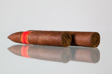 Different cigars on a  glass desk