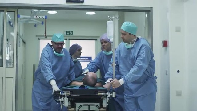 Hospital Emergency Team Carrying Stretcher with Patient through Hospital Hall. Shot on RED Cinema Camera.