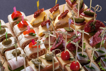 Different kinds of snacks canape on skewers. Selective focus