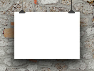 Close-up of one hanged horizontal paper sheet with clips on stone wall background