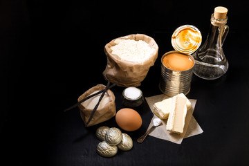 Ingredients for baking cake on black background. Toned