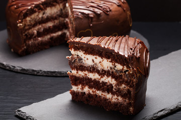 Chocolate cake on slate plate on black background. Selective foc