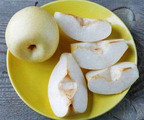 sliced yellow pear in a bowl on a rustic table