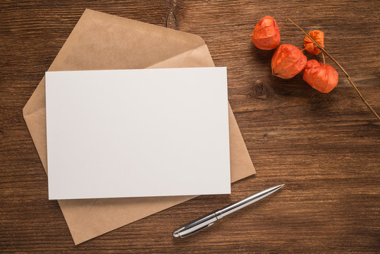 Flowers, envelope and pen on a wooden background 
