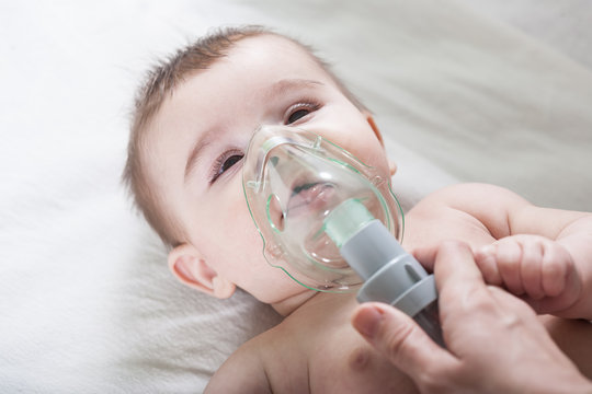 Doctor makes inhalation to a sick little baby.
