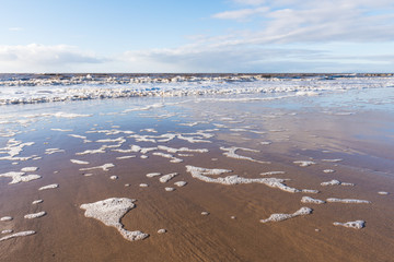 relaxing and gentle calming waves flowing into a beach at sundown