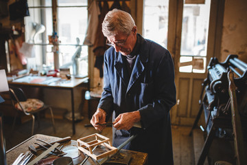 Senior tinsmith in his workshop. - obrazy, fototapety, plakaty