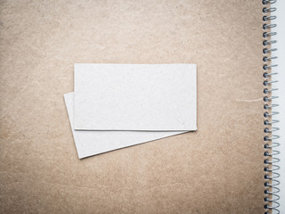 Blank business cards on kraft notebook cover, mockup