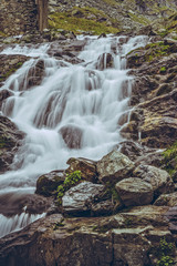 Majestic mountain stream waterfall nearby the famous Transfagarasan road in Fagaras mountains, Romania. Long exposure motion blur.
