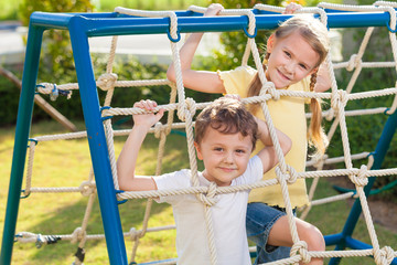 Obraz premium happy brother and sister playing on the playground