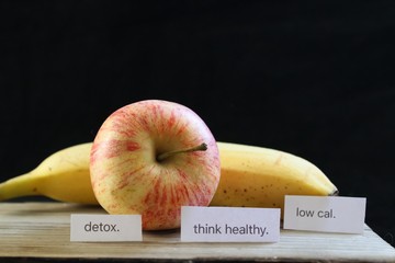 An organic apple and banana next to key dieting words and phrases
