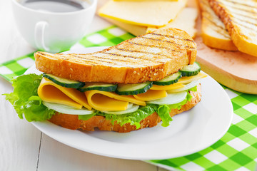 Sandwich with cheese, lettuce and vegetables for breakfast with coffee