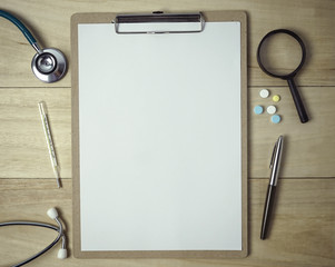 medical equipment and white paper on a clipboard for medical concept background
