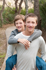 Fototapeta premium Portrait of two handsome boys riding piggy back