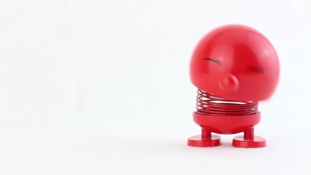 Red figure with metal spring laughing and jumping for creative use