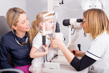 Little girl checking her vision at optometrists office 
