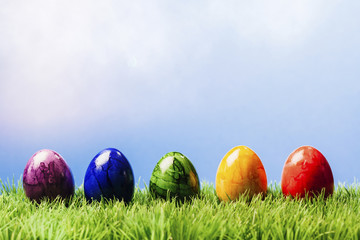 Reihe von Oster Eier im Gras, blauer Hintergrund