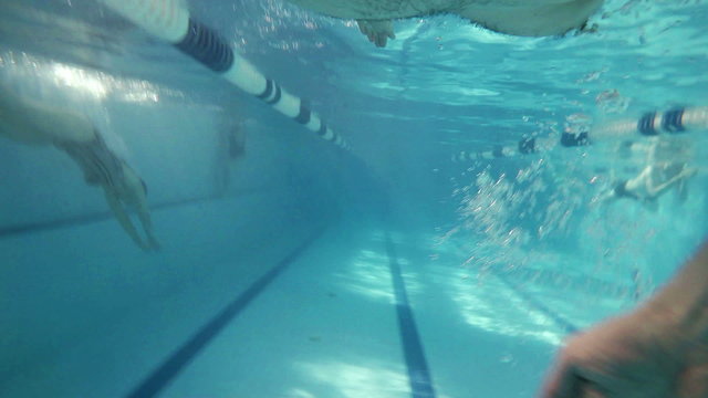 FREESTYLE: An athlete is swimming in a swimming pool (underwater view - action cam)
