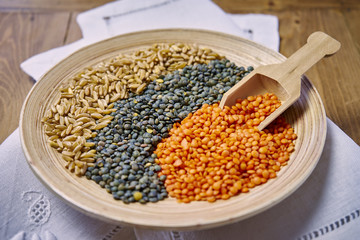 Kamut Khorasan und bunte Linsen in Schale auf Holztisch