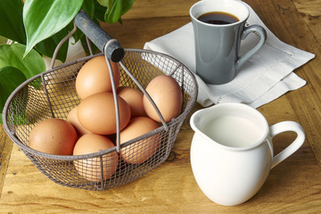 Eier, Kaffee und Milch am rustikalen Tisch zum Frückstück
