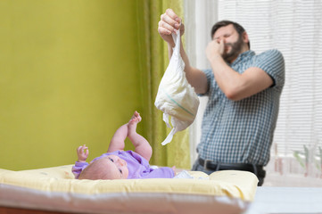 Baby care concept. Father od dad is changing stinky diaper. - obrazy, fototapety, plakaty