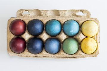 Easter, colorful painted eggs in in a cardboard box. Each color is from the different natural colorant.