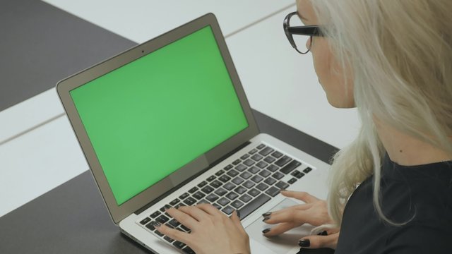 Girl Typing and Using Touchpad on Laptop with Green Screen in Office 