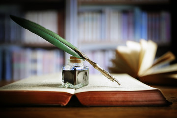 Quill pen on an old book in a library