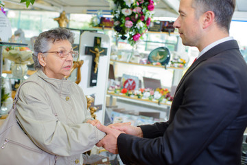 Undertaker shaking hand of elderly lady