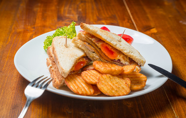 Sandwich with eggs and ham, served on a white plate. Breakfast, dinner.