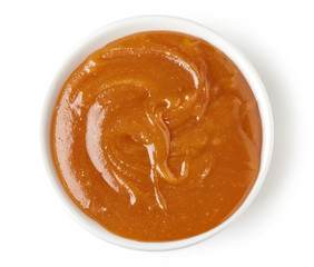 Caramel sauce  in round dish isolated on white background