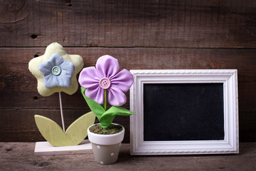 Empty  blackboard and decorative flowers on wooden background.