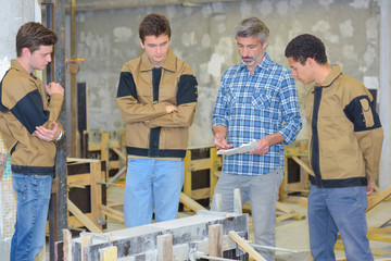 Obraz na płótnie Canvas Teacher with three students in practical class