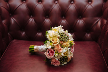 Beautiful wedding bouquet in rustic style with roses on brown le