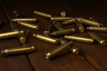 Empty rifle shells on dark wooden board
