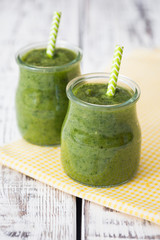 Green smoothie with apple,banana and spinach on a light backgrou