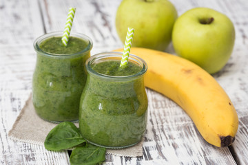 Green smoothie with apple,banana and spinach on a light backgrou