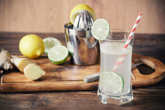 Homemade lemonade with lemon and ginger on a wooden background